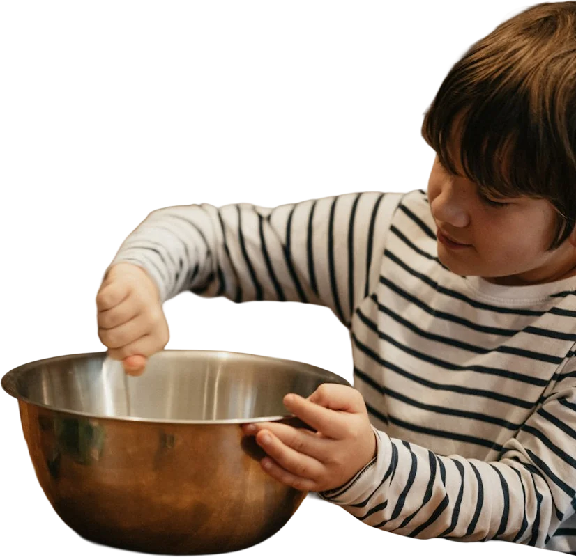 A child stirring a large mixing bowl