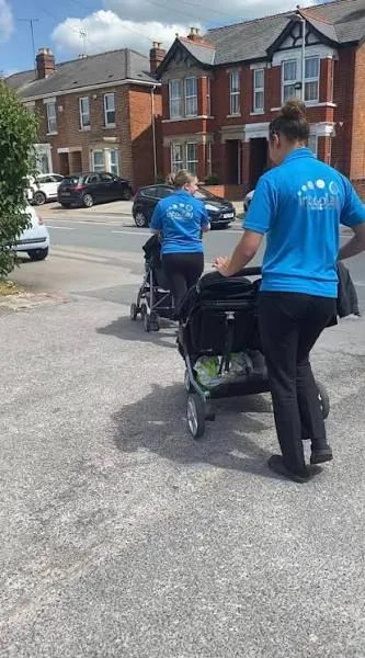 Two team members taking children out for a walk in buggies