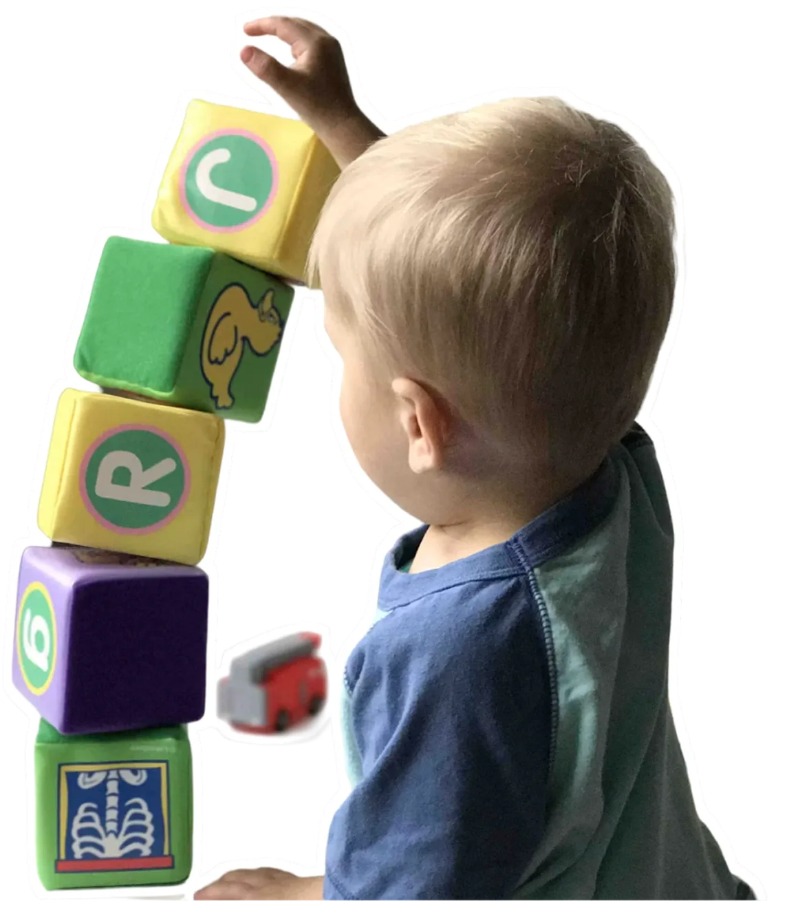 A young child stacking soft alphabet blocks